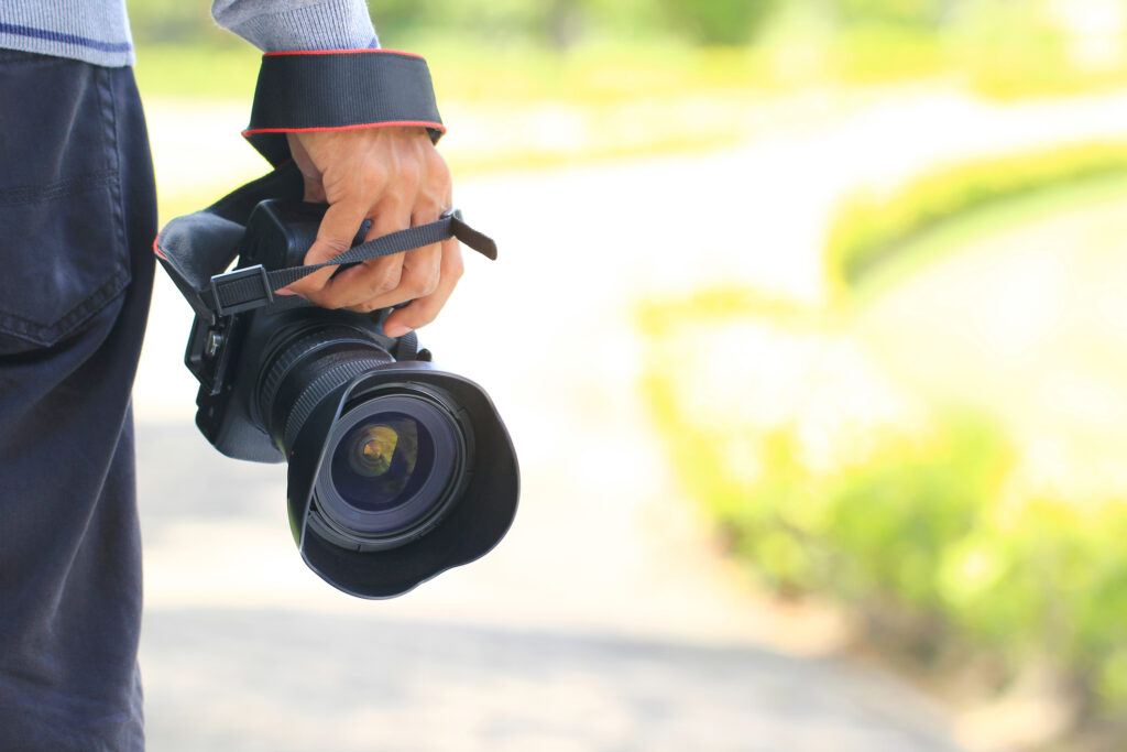 Photographer holding DSLR camera in his hands, ready for legal surveillance