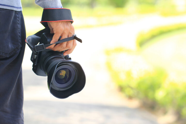 Photographer holding DSLR camera in his hands, ready for legal surveillance